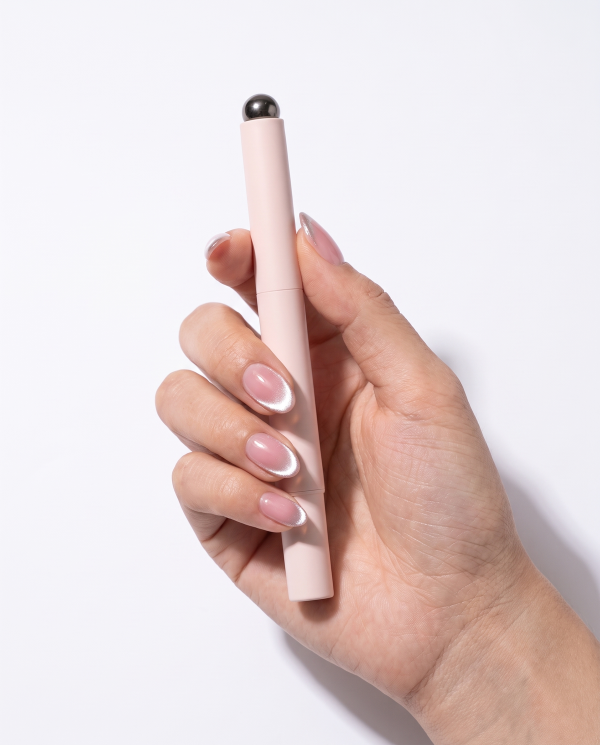 Lumia cat eye gel pen held in a hand with finished cat eye nails