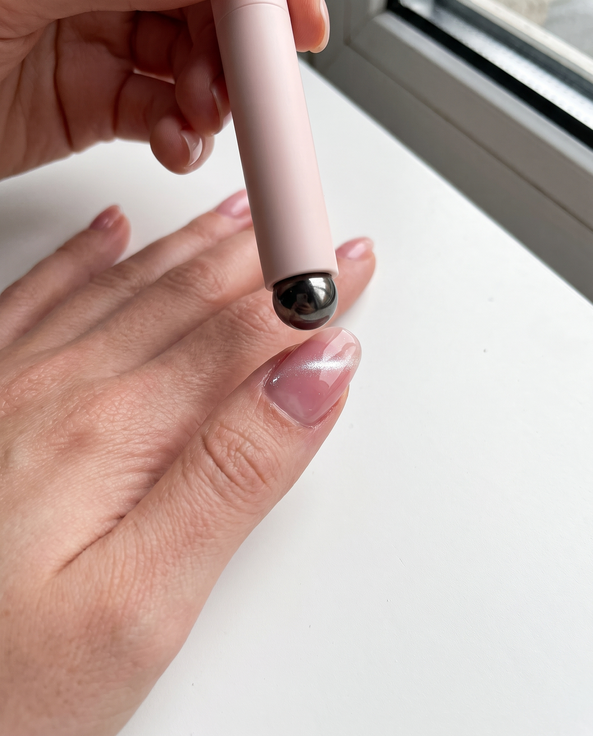 The magnet end pulling the shine across a wet gel nail